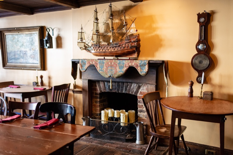 Jessop's Tavern dining room with a colonial-era fireplace and model ship